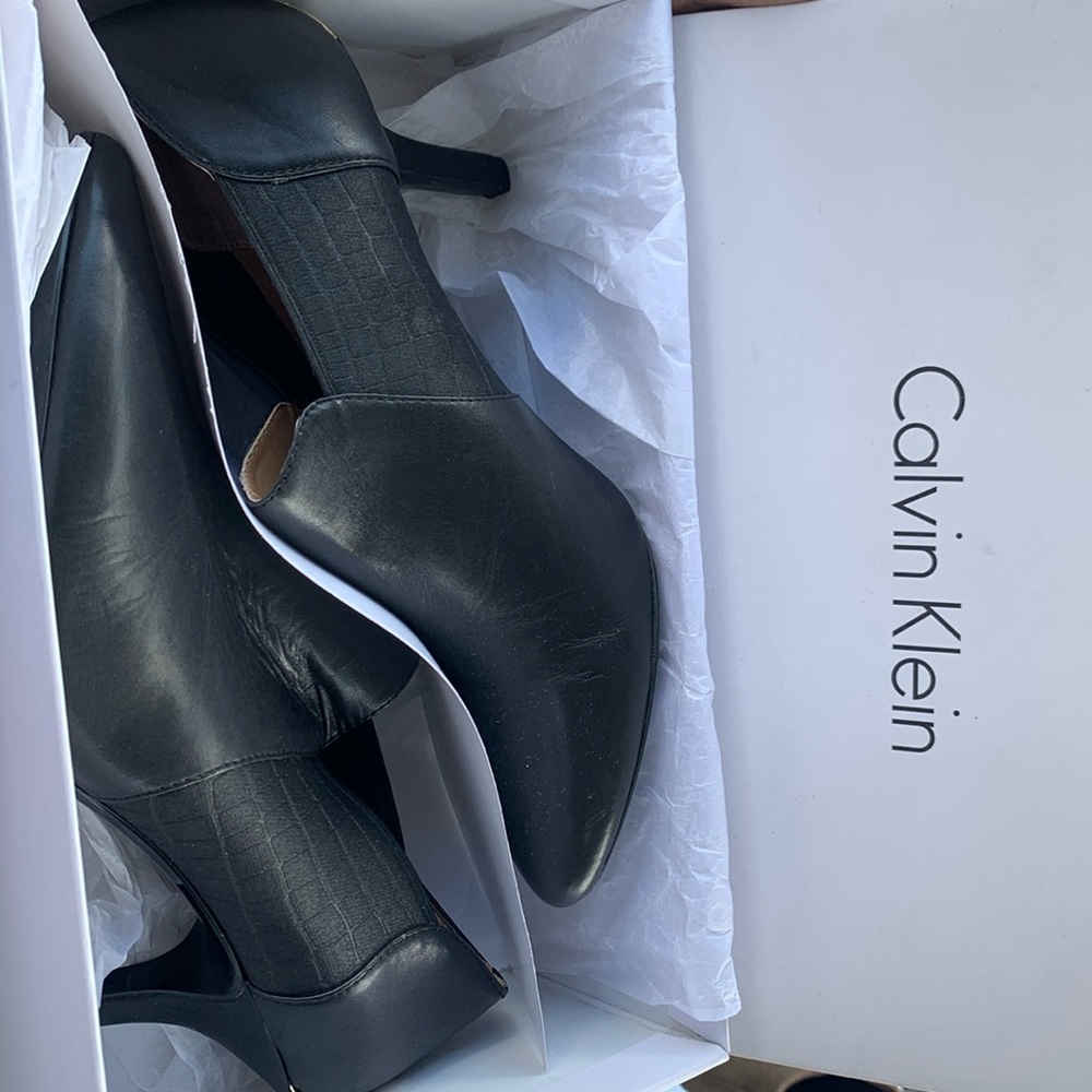 Black low cut shoe boots with gold accents.